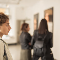 woman studying a painting at an art gallery