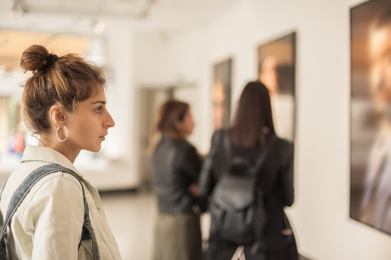 woman studying a painting at an art gallery